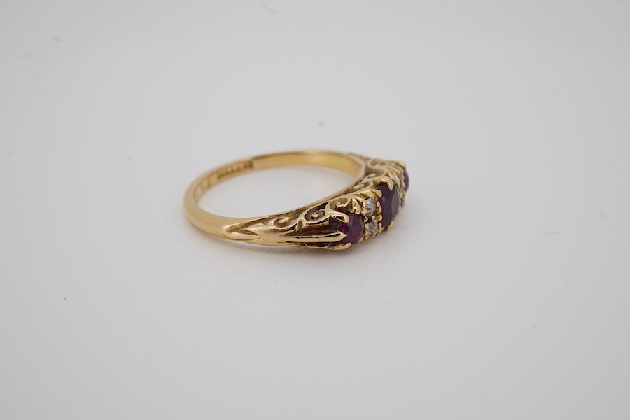 An Edwardian 18ct gold, three stone ruby and four stone diamond set half hoop ring, size K, gross weight 3.4 grams. Condition - fair